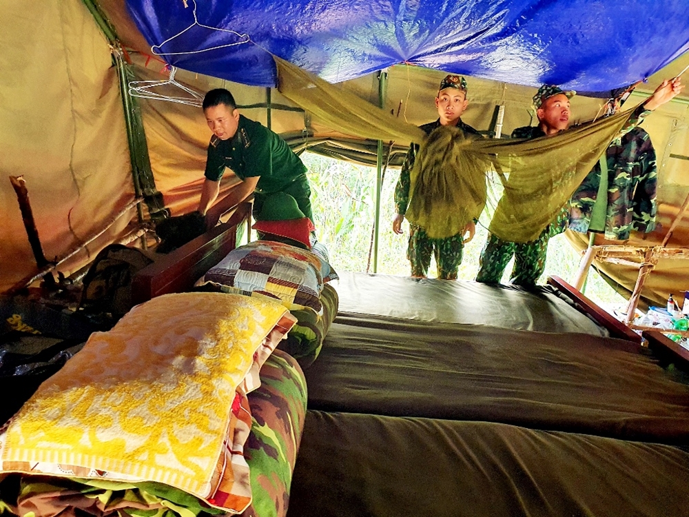 Lán trại được kê 3 chiếc giường làm nơi nghỉ ngơi của các anh. Để tránh nắng nóng và giông lốc, mưa đá, các anh phải “thiết kế” thêm lưới chống nhiệt và 1 tấm bạt dưới mái lán.